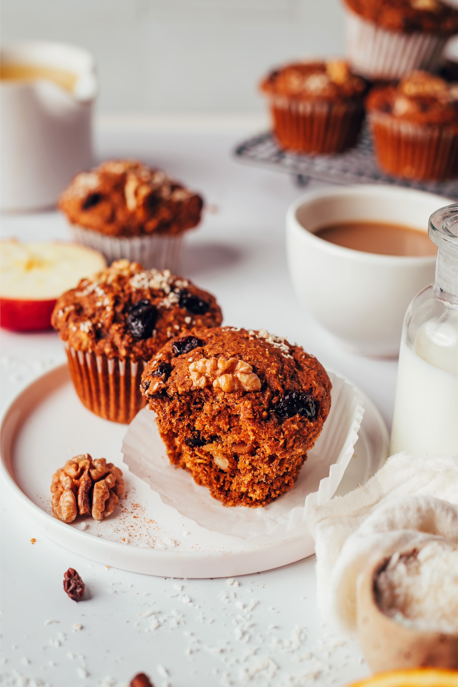 Plate with two vegan gluten-free morning glory muffins with more muffins in the background